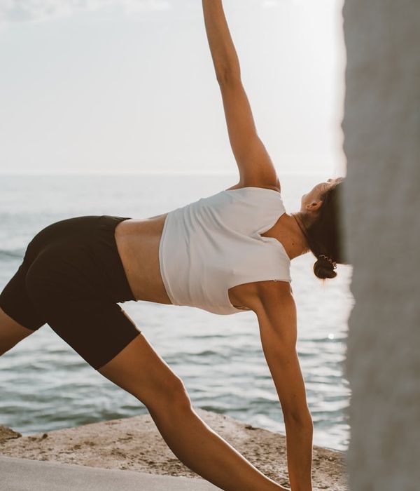 Person feeling energized and stretching outdoors at sunrise.